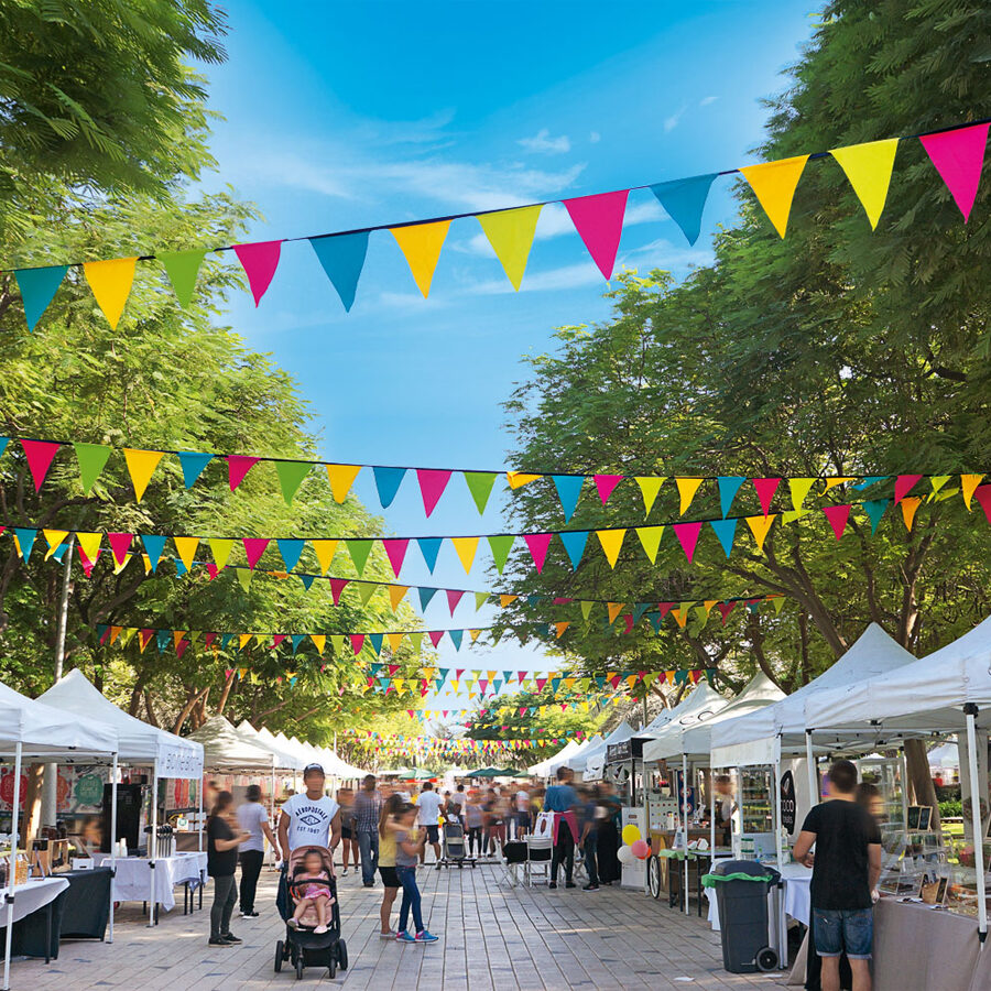 Outdoor market on a street with strings of flags